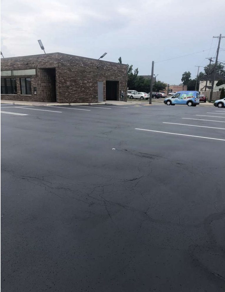 A parking lot with cars parked in front of a building