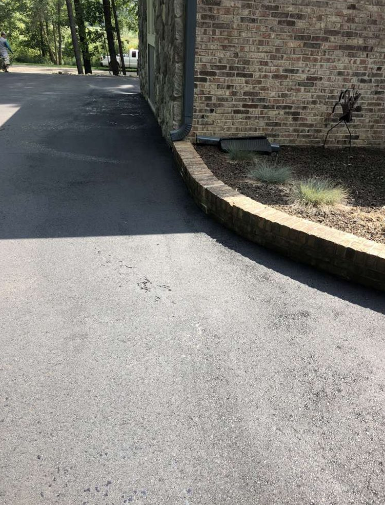 A driveway with a brick building in the background