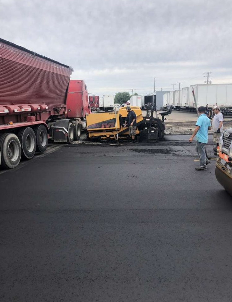 A truck is parked in a parking lot next to a machine