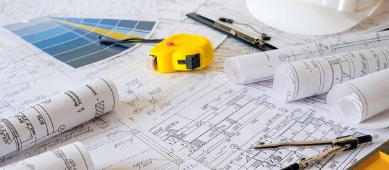 A yellow tape measure is sitting on top of a blueprint.