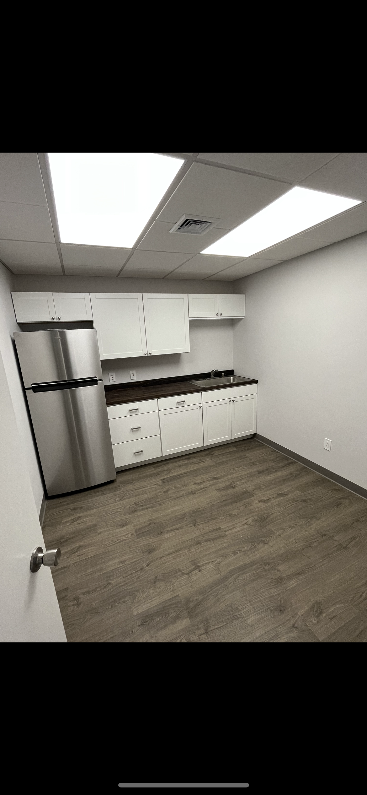 A kitchen with stainless steel appliances and white cabinets.