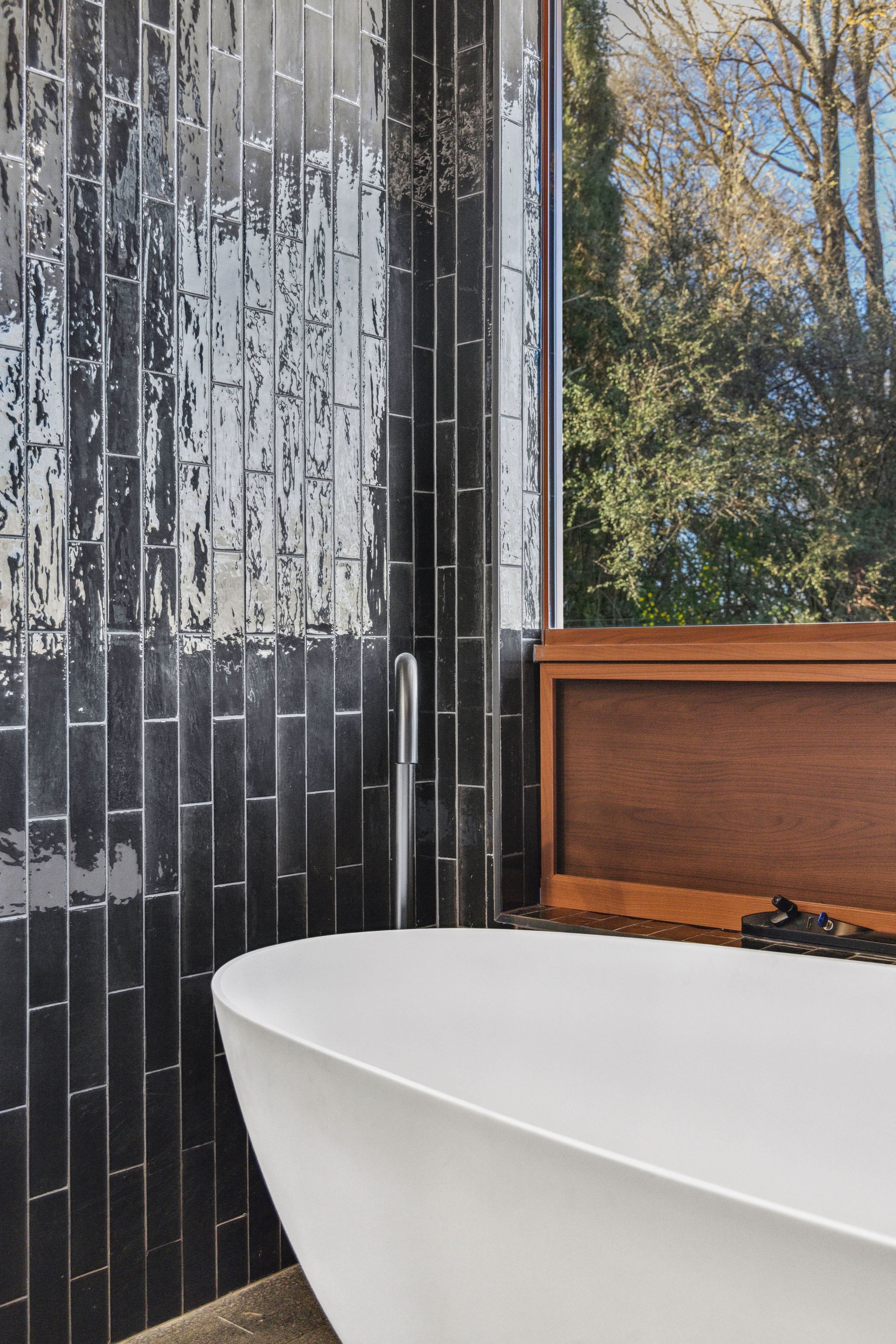 Modern Bathroom With White Tub, Black Tile Wall — Croker Plumbing and Gas in Goulburn, NSW
