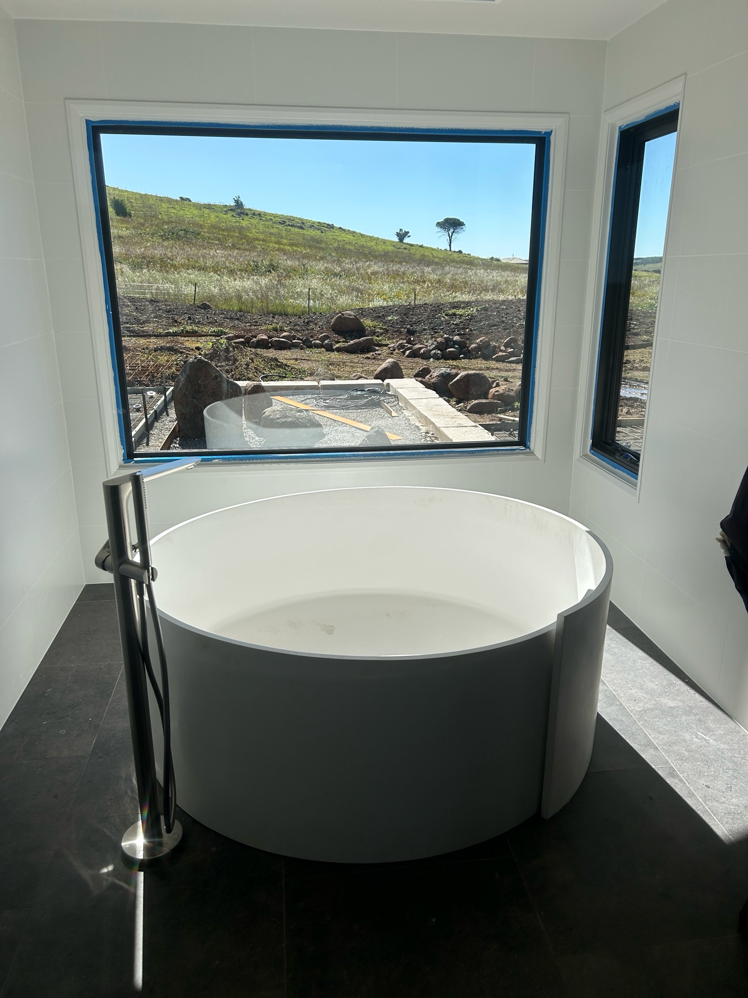 Bathroom With a Round, White Tub Near a Window — Croker Plumbing and Gas in Goulburn, NSW