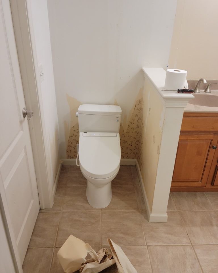 A toilet is sitting in a bathroom next to a sink.