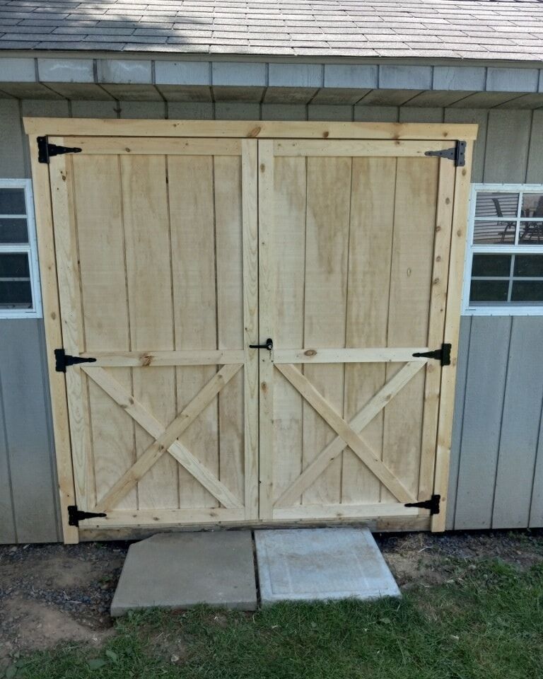 A shed with a wooden door that looks like a barn door work done by EK Painting in central PA