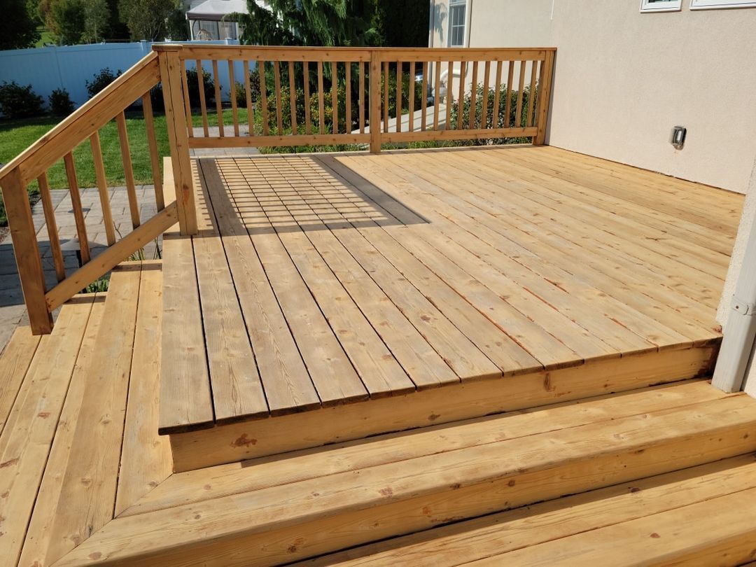 A wooden deck with stairs and a railing work done by EK Painting in central PA