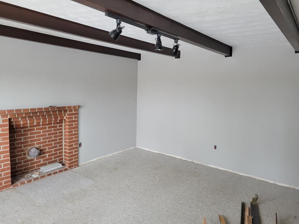 An empty living room with a brick fireplace and white walls