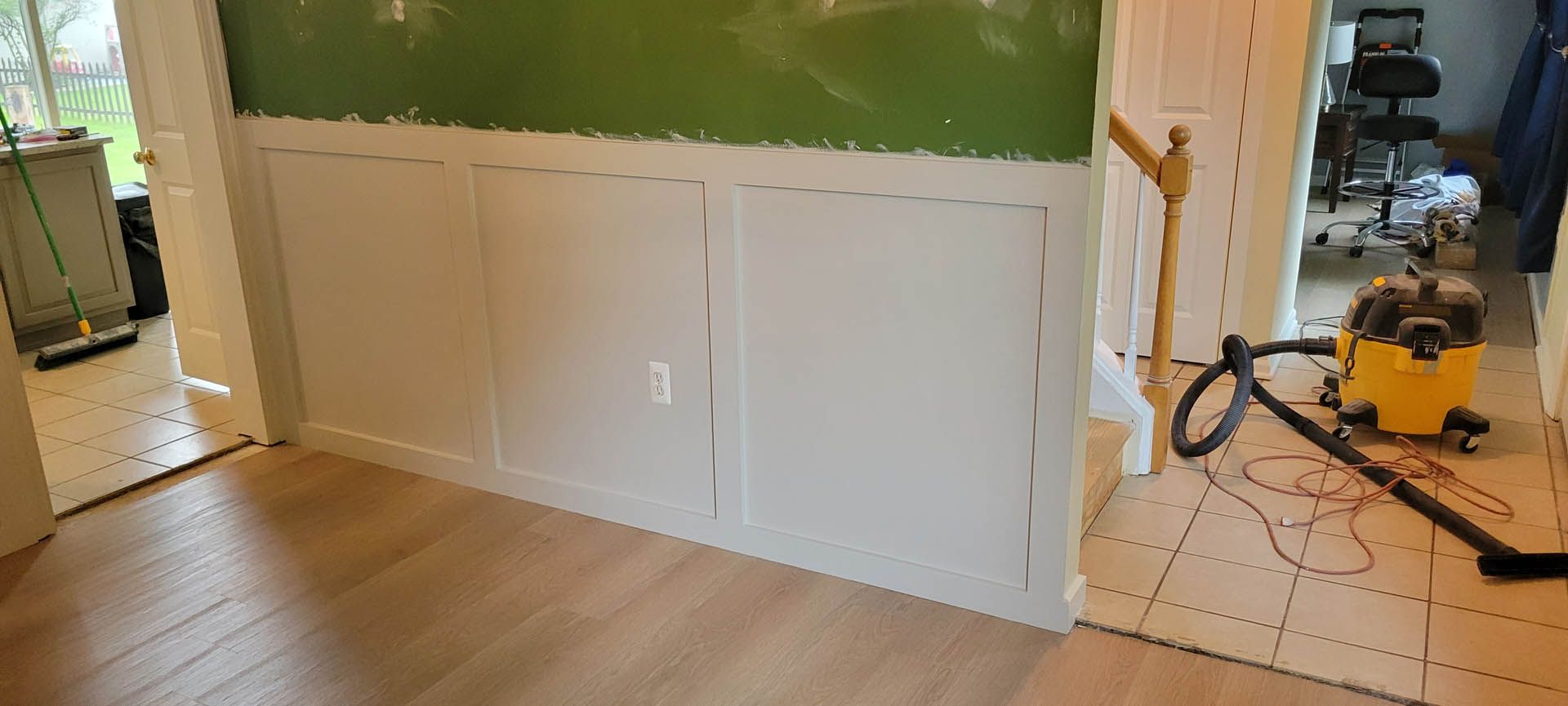 A hallway with a staircase and a white wall