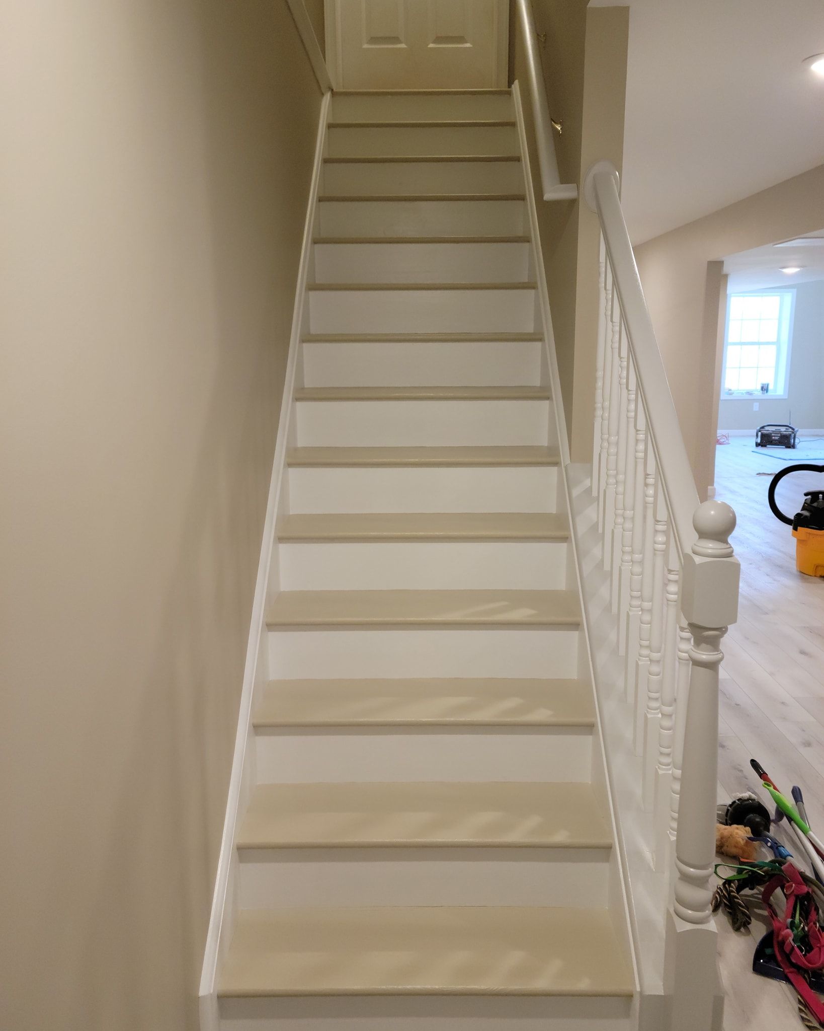 A white staircase with a white railing is leading up to the second floor of a house in New Holland, PA