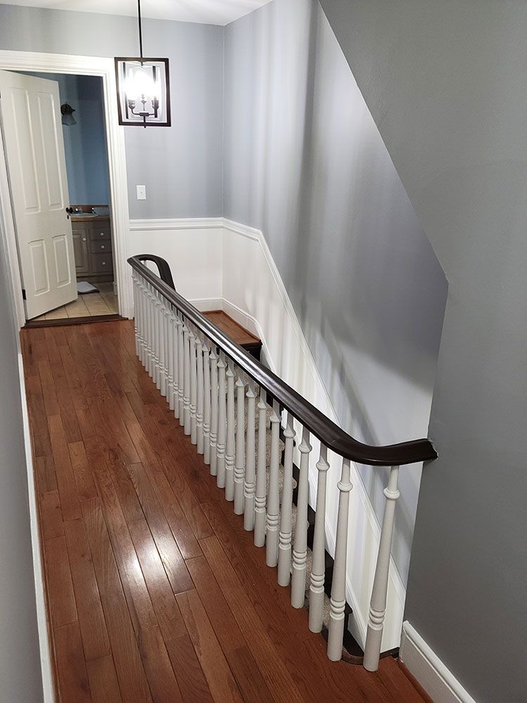 A hallway with a staircase leading up to the second floor of a house.