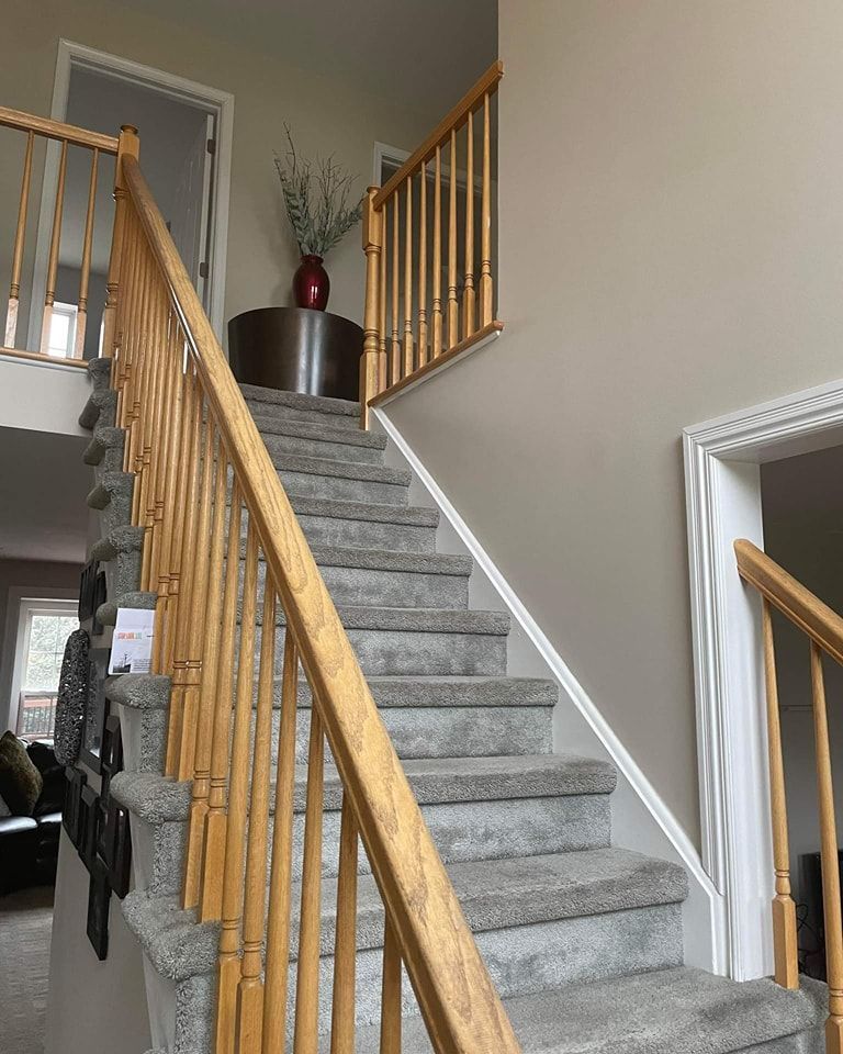 A staircase with a wooden railing leading up to the second floor of a house in Bowmansville, PA