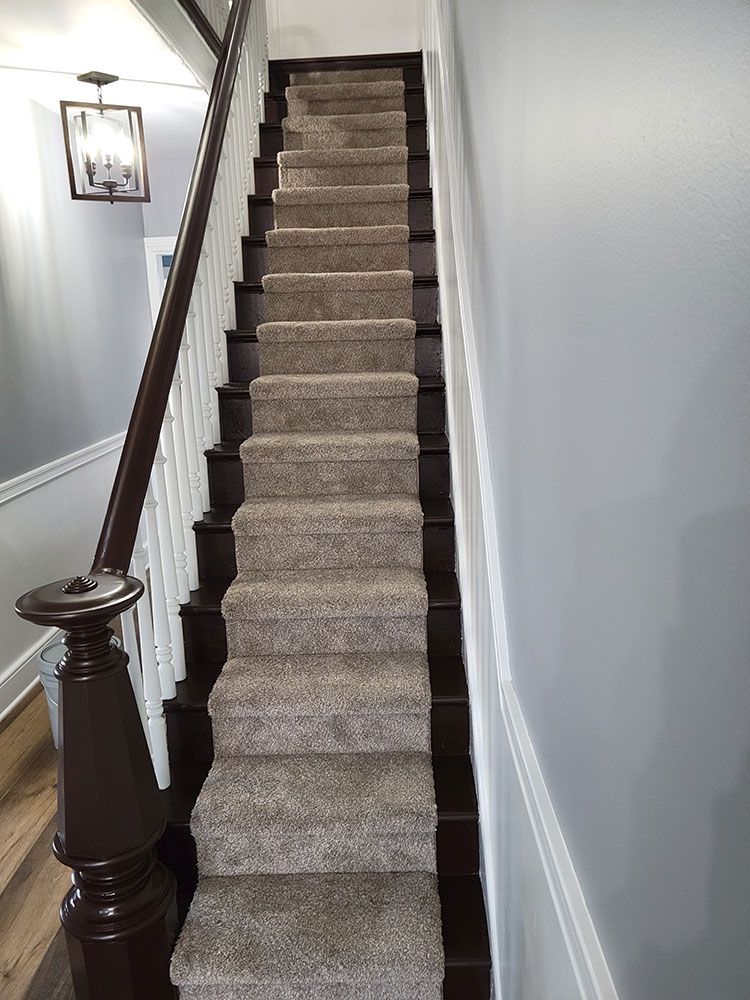 a staircase with a carpeted staircase and a wooden railing .