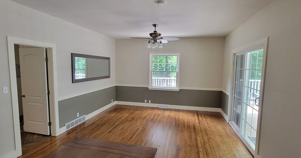 Interior Painting in Lancaster PA of an empty living room with hardwood floors and a ceiling fan.