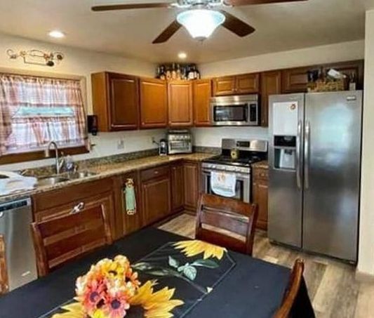 a kitchen with a table and chairs and a ceiling fan .