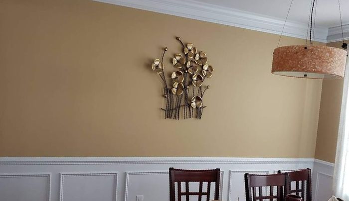 A dining room with a table and chairs and a wall decoration by EK Painting local painter for central PA.