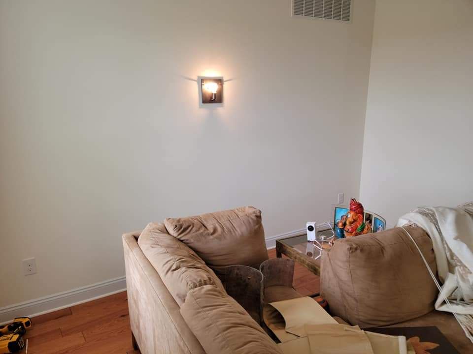 A living room with a couch , table , and wall light.