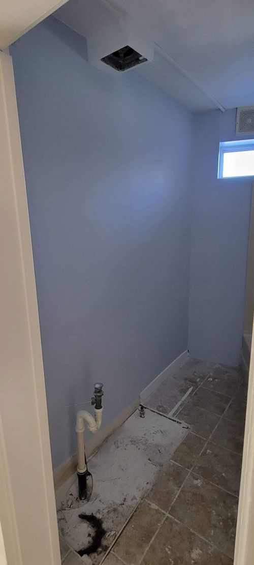 A bathroom with blue walls and tile floors is being remodeled.