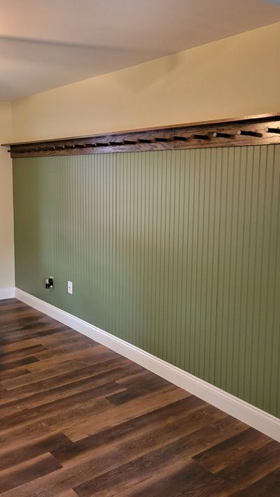 A hallway with a staircase and a white wall