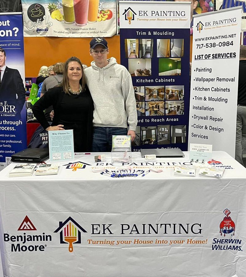 A man and a woman are standing in front of a table for ek painting