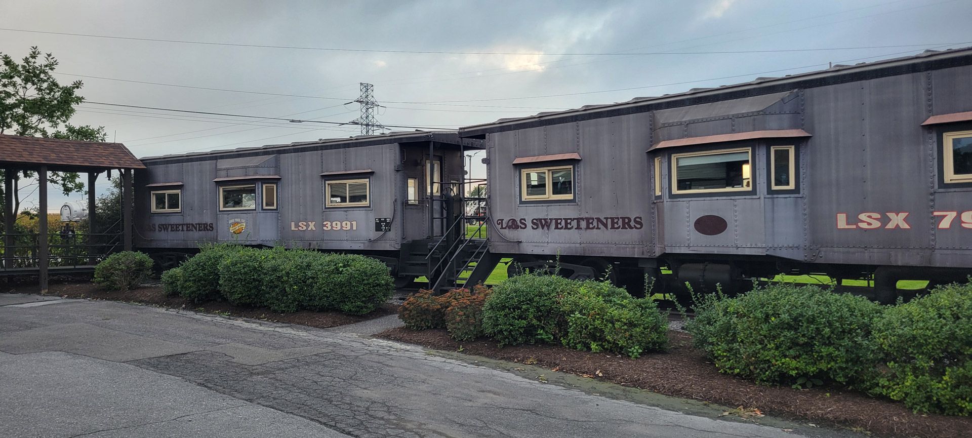 A train car is parked on the side of the road.