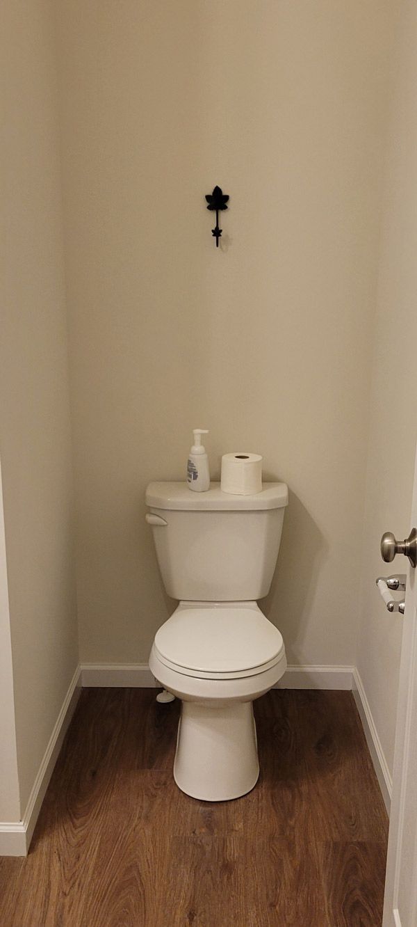 A toilet is sitting in a small bathroom next to a door.