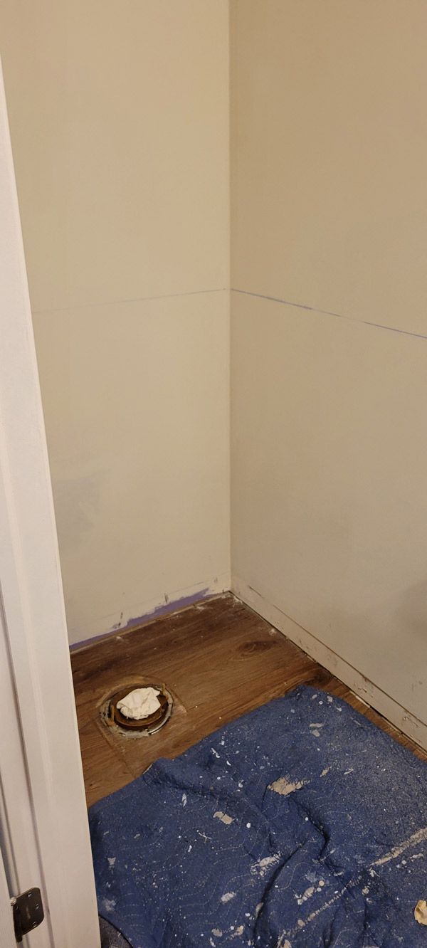 A bathroom under construction with a blue tarp on the floor.