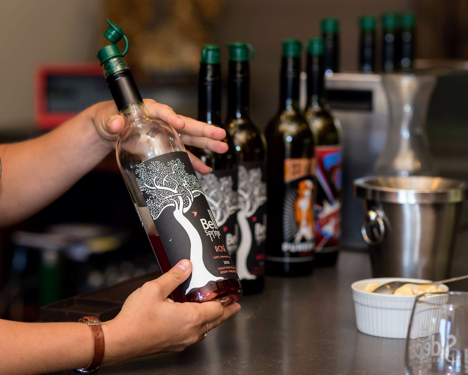A person is holding a bottle of wine in their hands.
