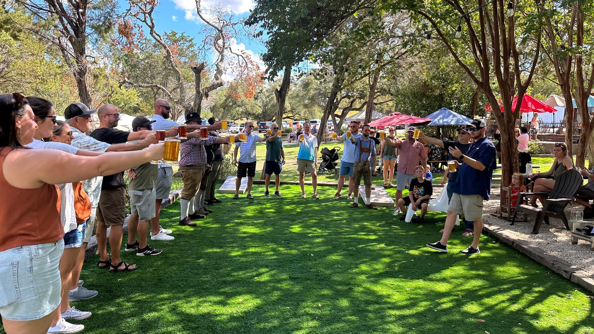 People toasting with beer outdoors on a sunny day.