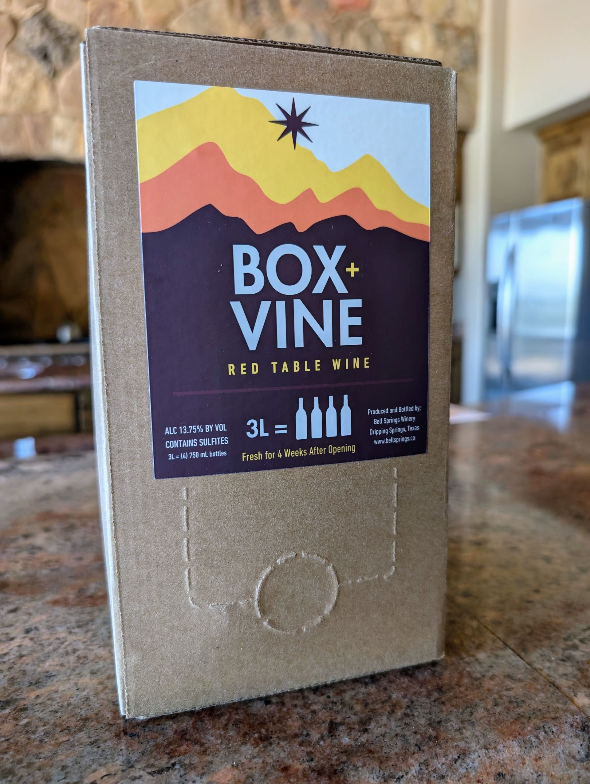 Box of Box Vine red table wine on a countertop, featuring a mountain logo.
