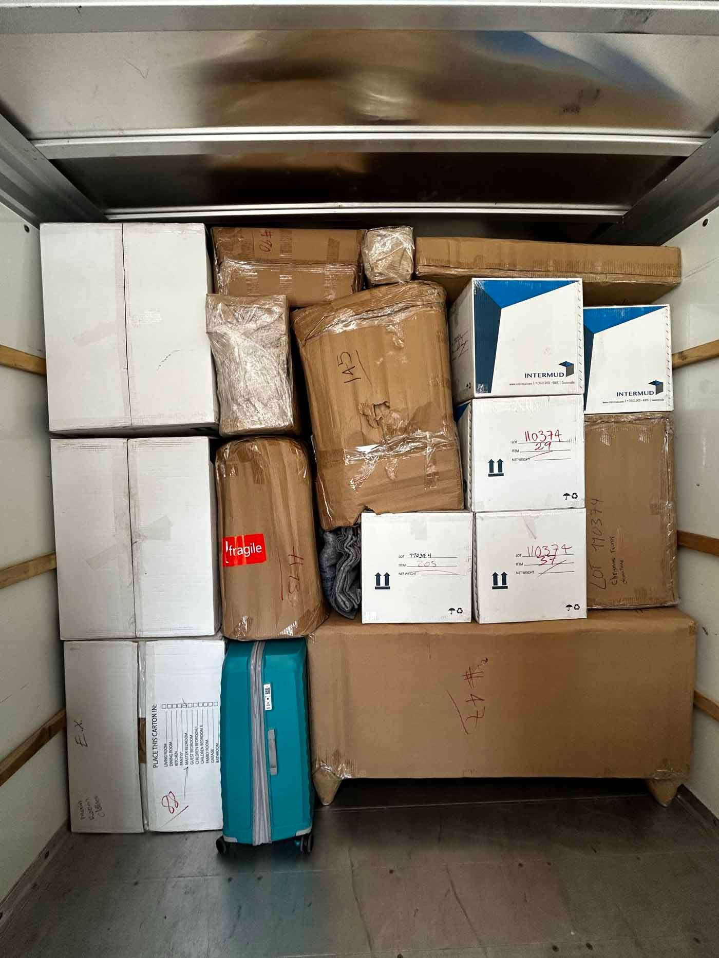 A truck filled with boxes and a blue suitcase