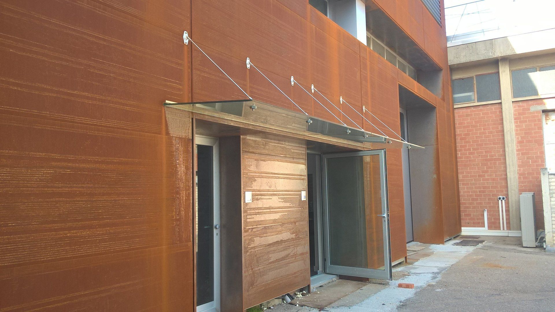 PENSILINA IN VETRO E ACCIAIO INOX SU RIVESTIMENTO IN ACCIAIO COR-TEN