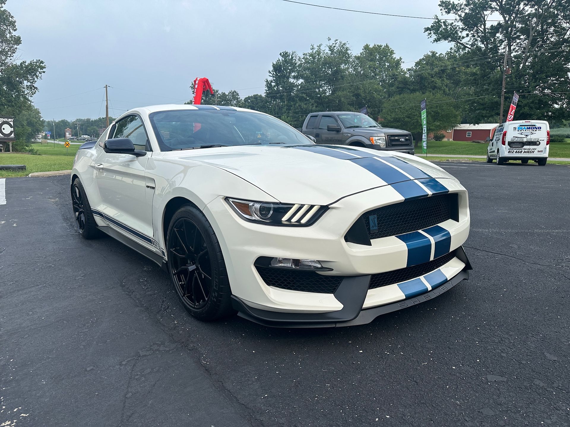 a white and blue ford mustang is parked in a parking lot .