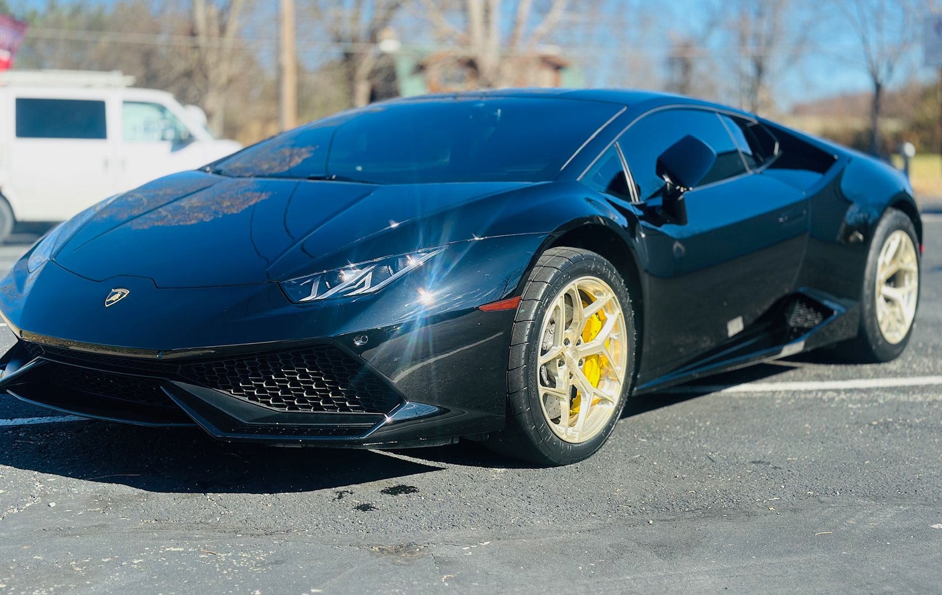 a black lamborghini huracan is parked in a parking lot .