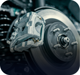 A close-up of a metallic automotive disc brake assembly featuring the caliper mounted over the rotor | Ames Automotive STC