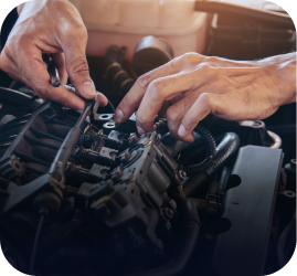 Hands working to repair or maintain the complex components of an open car engine | Ames Automotive STC