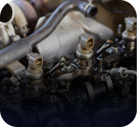 Close-up of a dirty internal combustion engine featuring fuel injectors, metal rocker arms, and wiring components | Ames Automotive STC