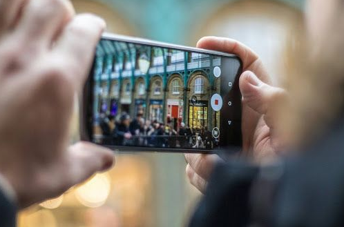 A person is taking a picture of a building with a cell phone.