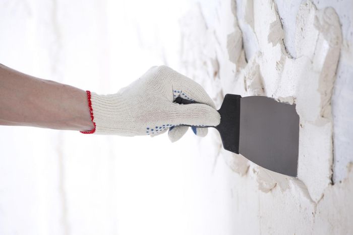 worker scraping the wall