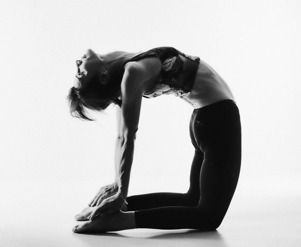 Une femme fait une pose de yoga sur une photo en noir et blanc