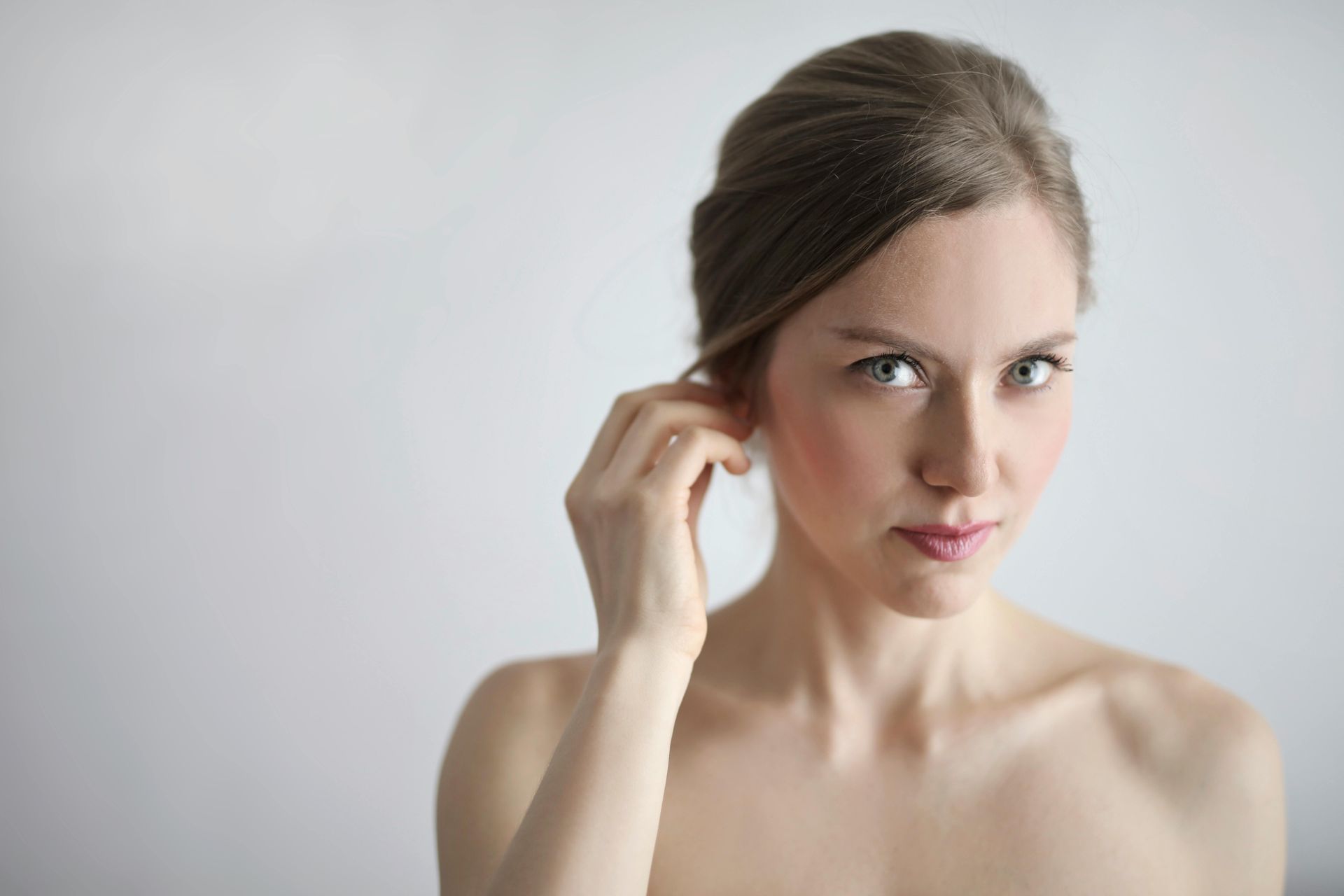 Une femme touche son oreille avec sa main.