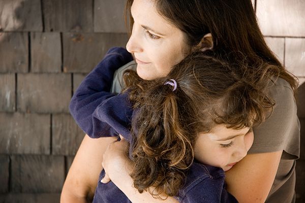 a woman is holding a little girl in her arms .