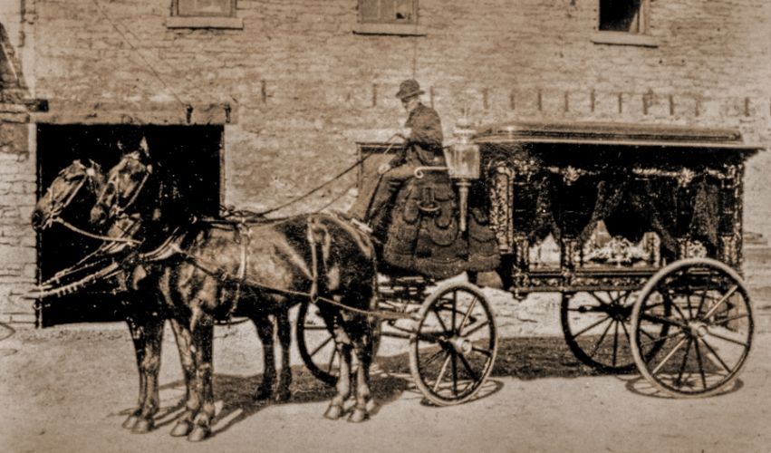 A black and white photo of a horse drawn carriage