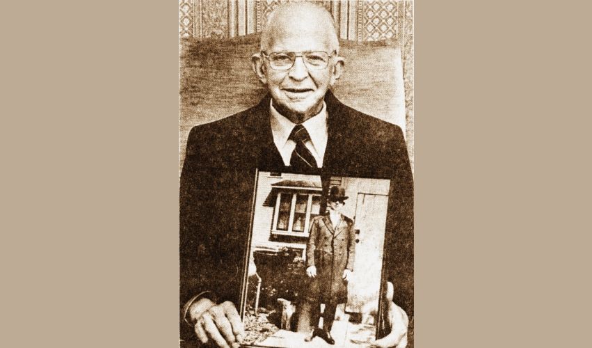 A man in a suit and tie is holding a picture in his hands.