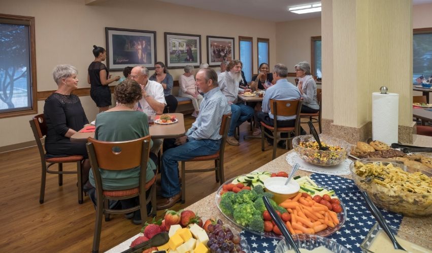 A group of people are sitting at tables in a room eating food.