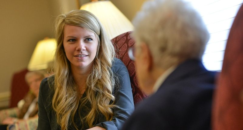 a young woman is talking to an older woman in a living room .