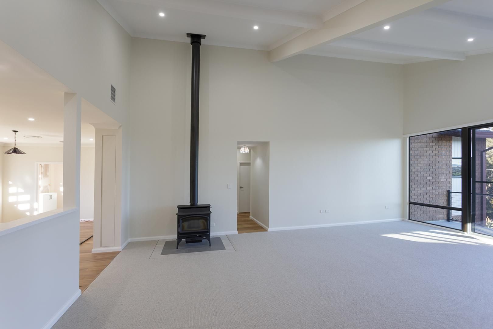 An Empty Living Room With a Wood Stove in the Middle of It — Kareela Constructions In Tamworth, NSW