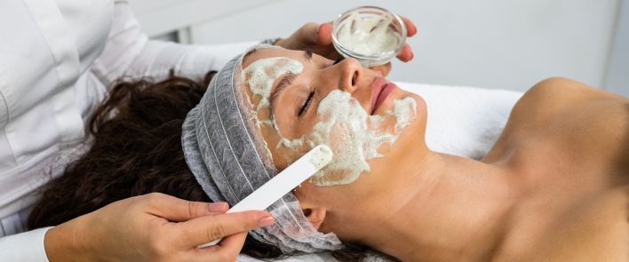A woman is getting a facial treatment at a spa.