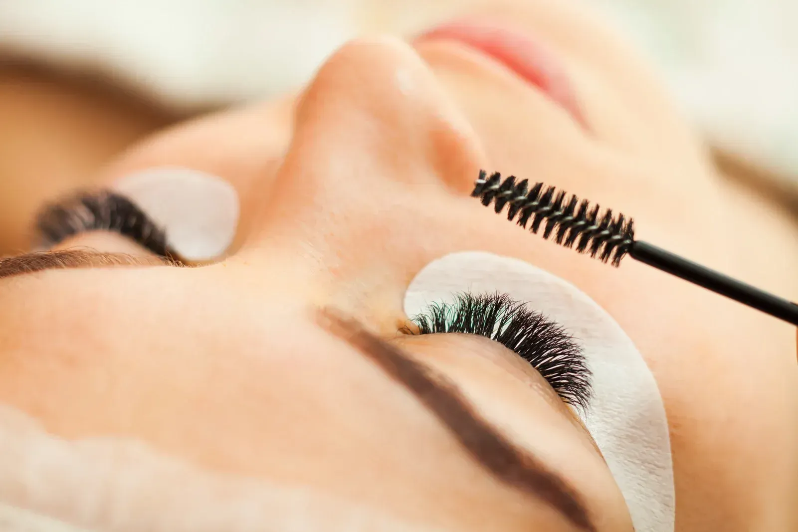 A woman is getting her eyelashes done at a beauty salon.