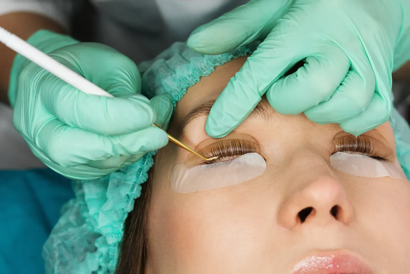 A woman is getting eyelash extensions in a beauty salon.