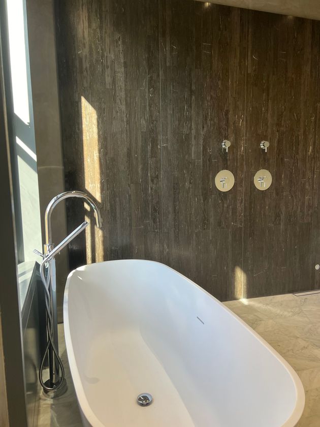 A bathtub is sitting in a bathroom next to a window.